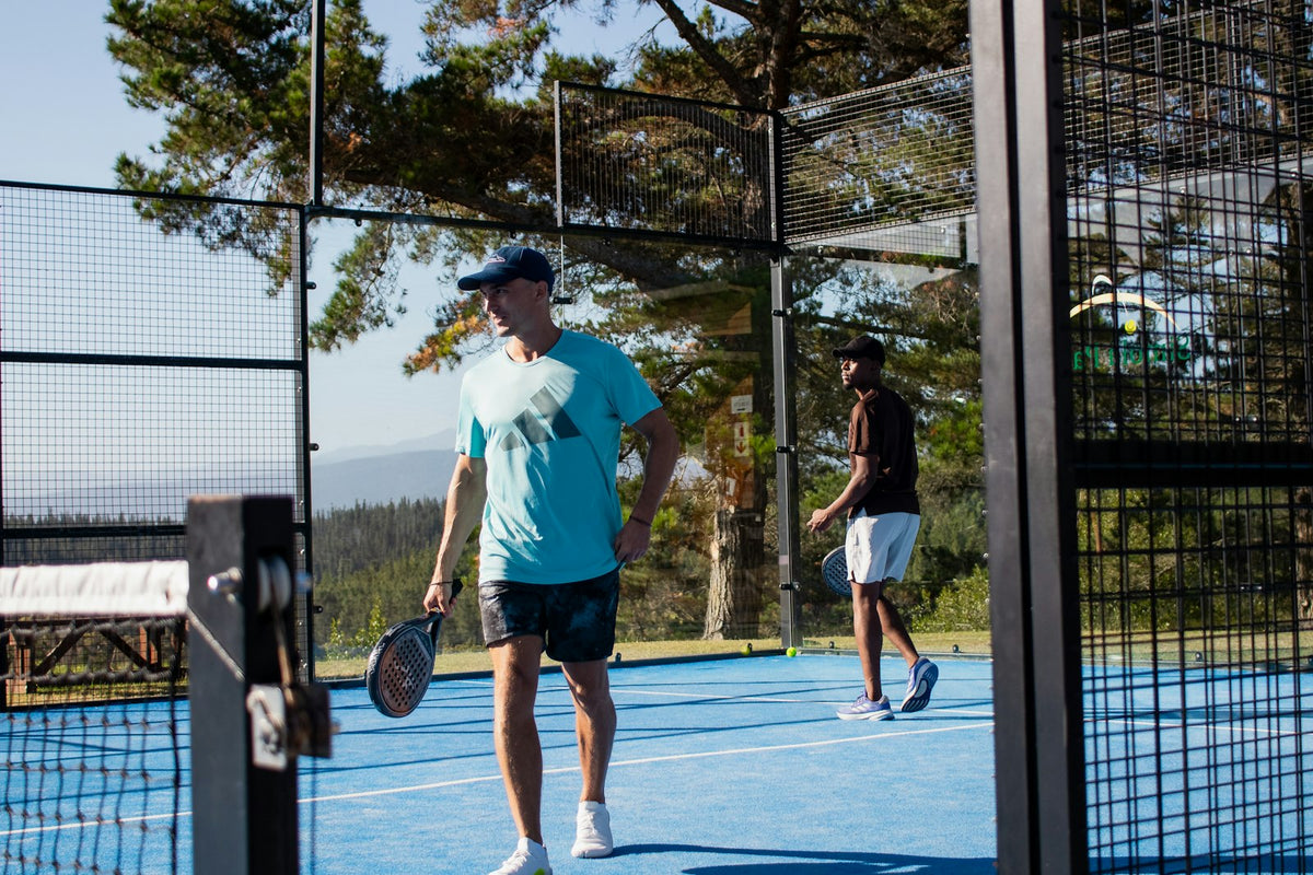 Dos jugadores de pádel en una pista al aire libre